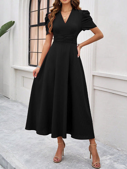 Midi-Cocktailkleid mit geraffter Taille, ausgestellten Ärmeln und Puffärmeln.